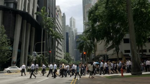 Crowd of business people crossing the street in downtown Singapore, Asia