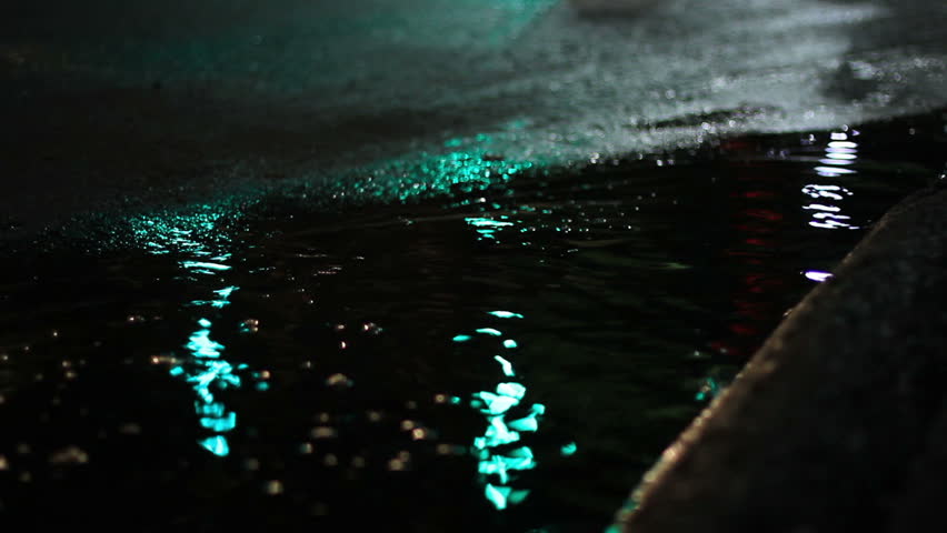 Unique urban shot of signal lights reflecting in a puddle at night in the