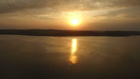 Aerial shoot of amazing summer sunrise about great lake. Water reflections