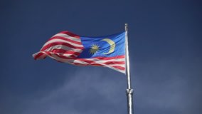 Real Malaysia flag waving on the blue sky in the wind, Malaysia national flag concept
