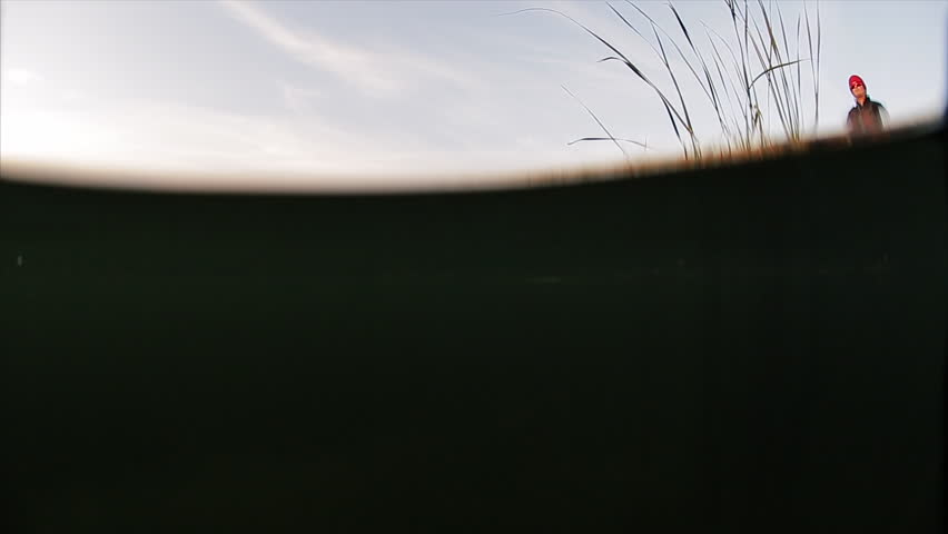 Man fishing from the boat. Split shot with underwater view of a lure moving