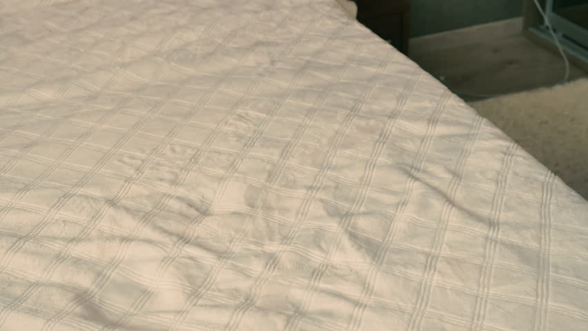 The mother changes clothes of baby on the bed