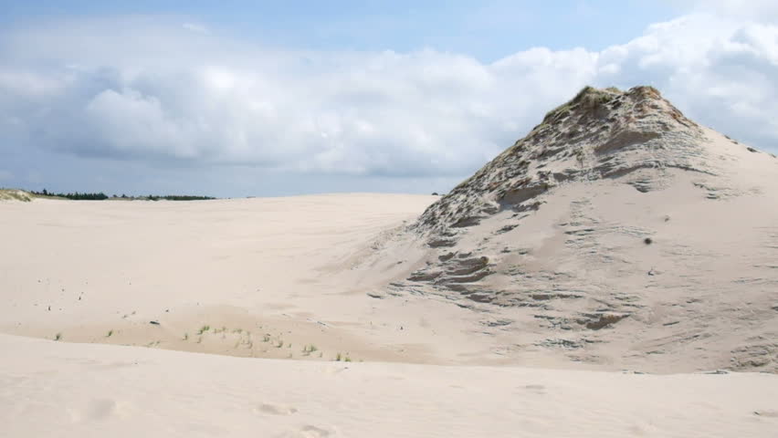 Baltic white sand beach and dunes with cloudy sky in Slovinski National Park, Leba, Poland.