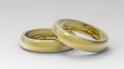 Two Beautiful Golden wedding rings rotate couple around axis isolated on white background in studio. Jewelry concept video, 3D animation