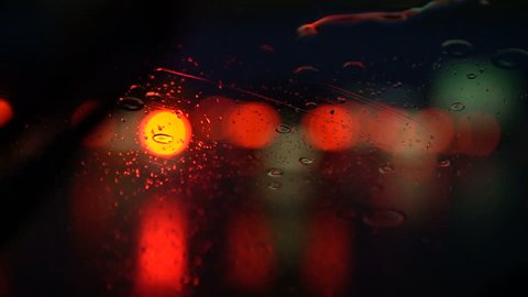 Night lights of cars in rain drops