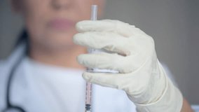 Close up of a medical syringe in hands of a professional doctor