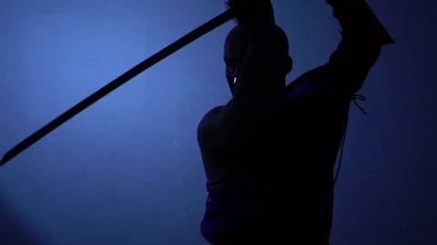 Bald Ninja in a mask fights in the dark, slow motion