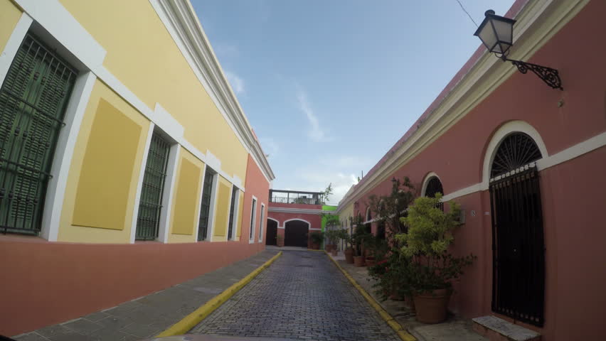 POV of Old narrow brick paved road and colonial houses in the old city of San Juan, Puerto Rico.  Old San Juan is a main spot for local and internal tourism 