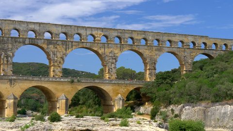 Panning shot of three-tiered aqueduct Pont du Gard on the river Gardon. Provence, France