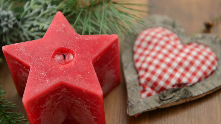 Christmas candle in star shape is lit with a match. In addition, a fir twig with a heart is made ??of birch wood and fabric. 