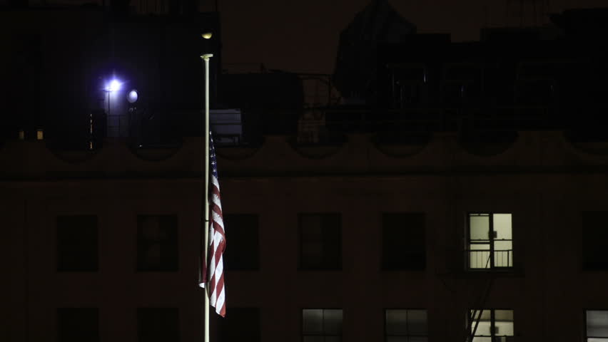 This is a zooming time lapse shot of the US Flag at night.
