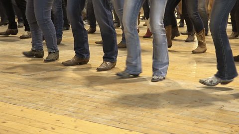 Cremona, Italy, May 2017 - People dancing bluegrass music, line dance at a folk event, cowboy USA style. Cowboy stepping choreography American horse festival. Tradition jeans boots and flag
