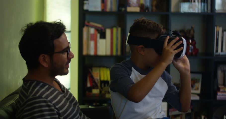 Slow Motion of kid sitting in his father's lap playing with VR headset | Shutterstock HD Video #29677561