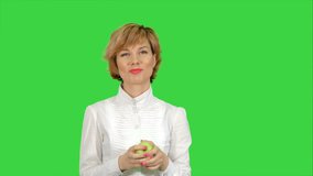Portrait of young woman eating green apple on a Green Screen, Chroma Key