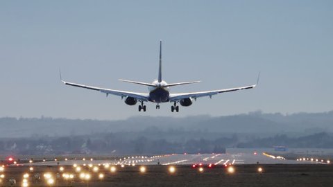 Commercial Jet Airplane Landing in airport runway in the morning.