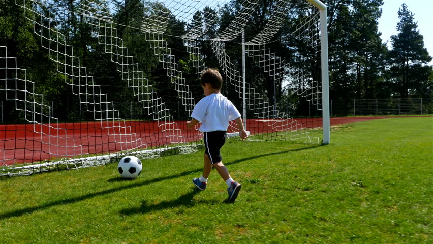 Tracking camera of a little 3 years old boy scoring a goal in a football field Royalty-Free Stock Footage #29695411
