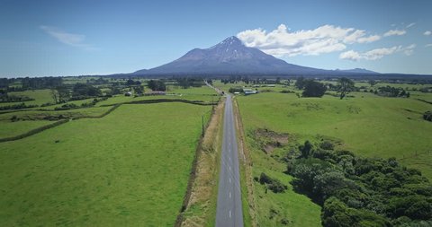 AERIAL: flying over a road looking out to Mt Taranaki / Mt Egmont, New Zealand