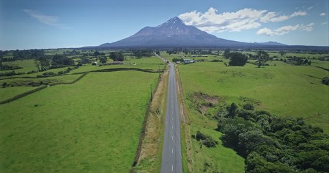 AERIAL: flying over a road looking out to Mt Taranaki / Mt Egmont, New Zealand