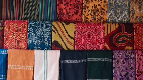 Colorful weaved sarong hang in rows in Sasak Sade traditional village in Lombok