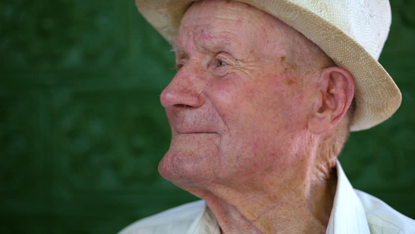Very old man portrait with emotions. Grandfather happy and smiling. Portrait: aged, elderly senior. Close-up of a pensive old man in white hat sitting alone outdoors at summer. Slow motion. Royalty-Free Stock Footage #29722513
