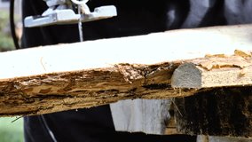 The video shows man is sawing the boards with an electric jigsaw