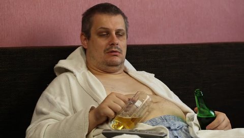 Drunk man asleep with a beer in his hands