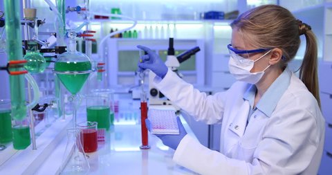 4K Busy expert woman pipetting microplate in chemistry lab, bacterial culture job