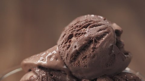 Slow motion of chocolate flakes falling on chocolate ice cream