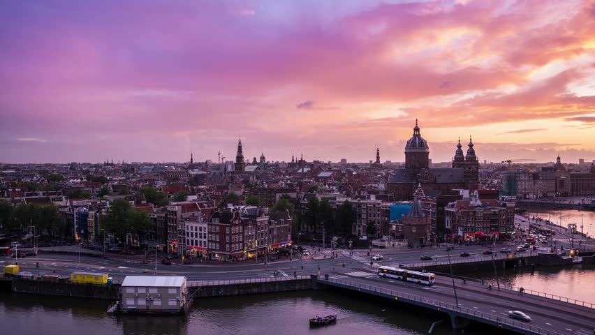 Beautiful 4K Timelapse day to night of Amsterdam skyline at sunset. The Netherlands, Europe.