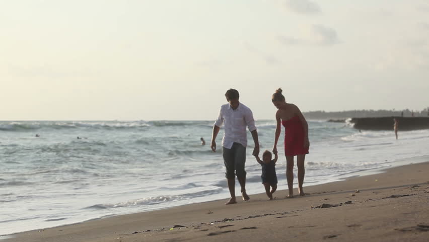Happy family walking on coast at holiday
