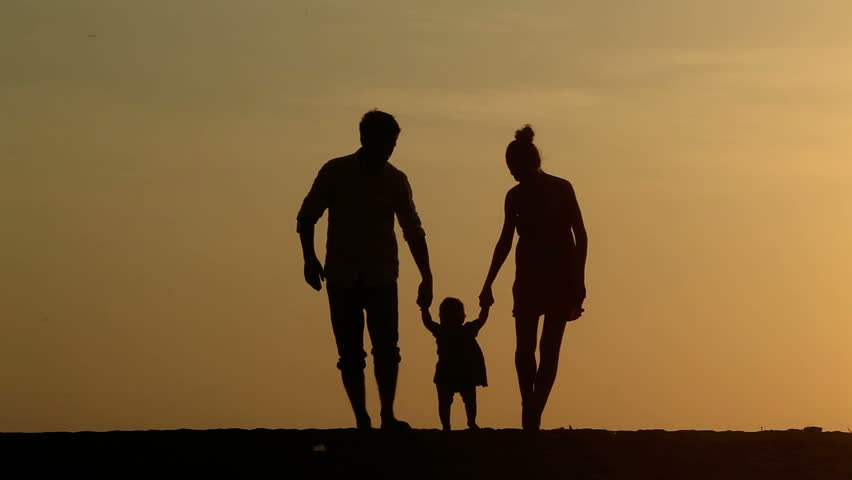 Silhouette of family walking together at sunset