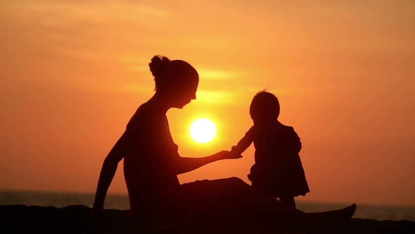 Silhouette of carefree mother and daughter over sunset