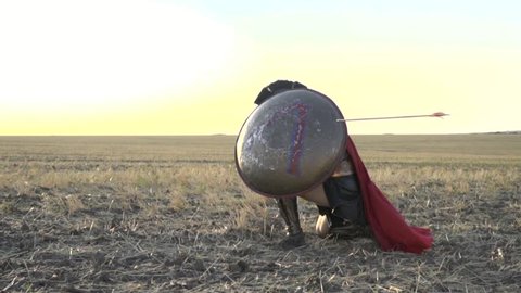 The gladiator hides behind the shield and receives an arrow from the side, slow motion