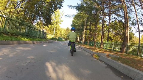 Happy boy in a helmet riding on a bike in a sunny summer day. Stock Video