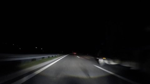 driving car in fast lane at night on highway with adaptive headlights