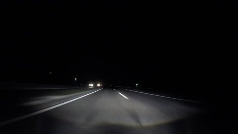 driving car in fast lane at night on highway with adaptive headlights
