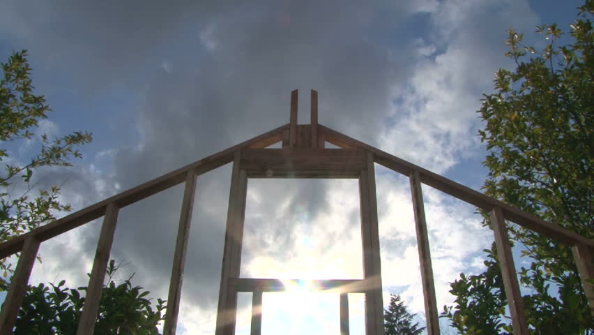 Time Lapse of clouds and sun shining through window on framework of new