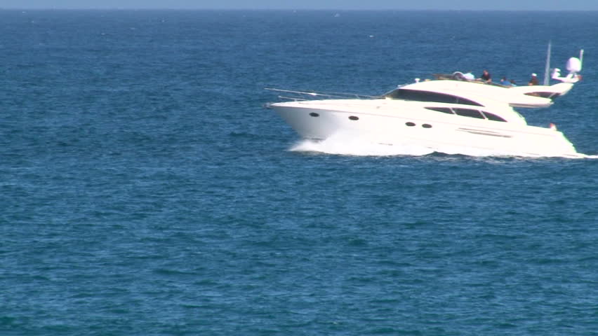 Yacht speeds by camera in ocean.