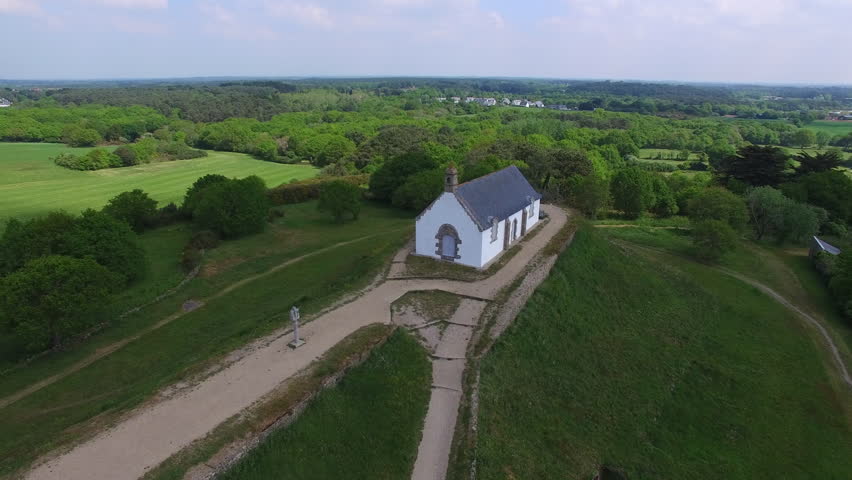 Flying over the Tumulus St Michel and its Chapel located in Carnac, a coastal city of the bay of Quiberon, Morbihan, Bretagne, France. Carnac is well-known for its famous rows of menhirs. | Shutterstock HD Video #29765785