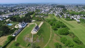 Flying over the Tumulus St Michel and its Chapel located in Carnac, a coastal city of the bay of Quiberon, Morbihan, Bretagne, France. Carnac is well-known for its famous rows of menhirs.
