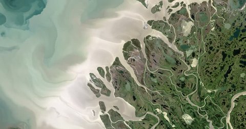 Very high-altitude overflight aerial of the Mackenzie River delta at the Beaufort Sea. Clip loops and is reversible. Elements of this image furnished by NASA