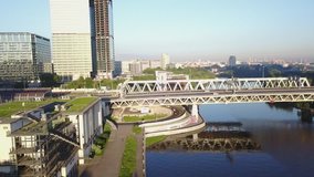 4K aerial view drone video of Moscow City area, International business centre, Moscow River with bridge, skyscrapers and boats along the river in Russia on calm sunny summer morning