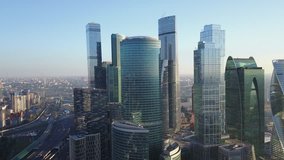 4K aerial view drone video of Moscow City area, International business centre, Moscow River with bridge, skyscrapers and boats along the river in Russia on calm quiet sunny summer August morning