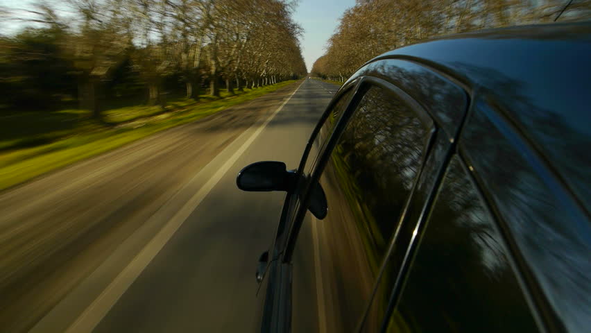 Driving a black sports super car POV. Right side reference. Country road, trees on the side, fall, day. Fast Speed / time-lapse. HD. Right side wheel / driving UK 
