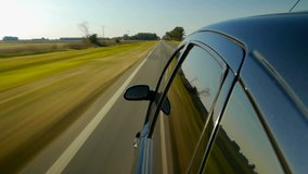 Driving a black sports / super car POV. Right side reference. Country road, trees on the side, fall, day. Fast Speed / time-lapse. HD. Right side wheel / driving UK 
