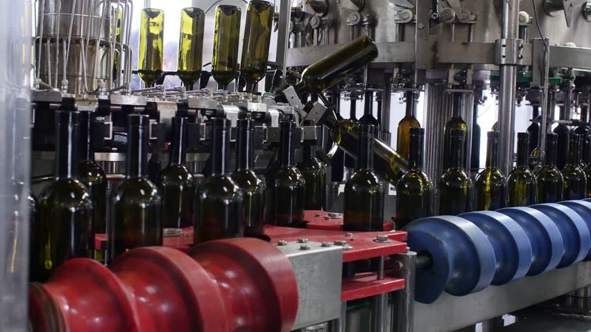 Spill of alcohol wine in glass bottles at the plant. Conveyor belt with glass bottles. The production process of alcoholic beverages. 4K res. Royalty-Free Stock Footage #29776291