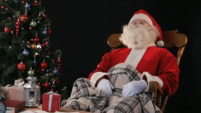 Santa Claus relaxing in a rocking chair having sweet dreams
