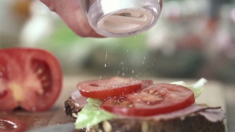 Hand sprinkle salt on sandwich, slow motion shot at 480fps
 Stock Video