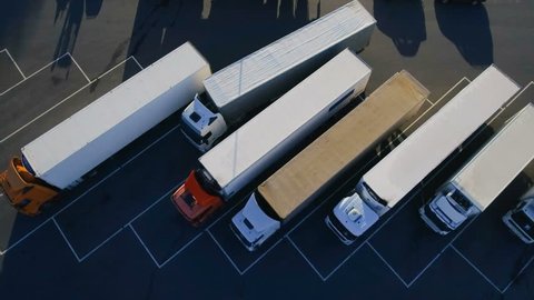 Aerial Top View of White Semi Truck with Cargo Trailer Parking with Other Trucks on Special Parking Lot. Shot on Phantom 4K UHD Camera.