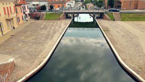 modern life and ancient architecture in an Italian lagoon town with traffic on old bridge and canal, graded clip